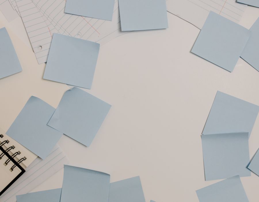 Notas adhesivas de papel en tonos azul grisáceo dispersas sobre una superficie clara